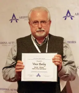 A man holding up an award in front of a sign.