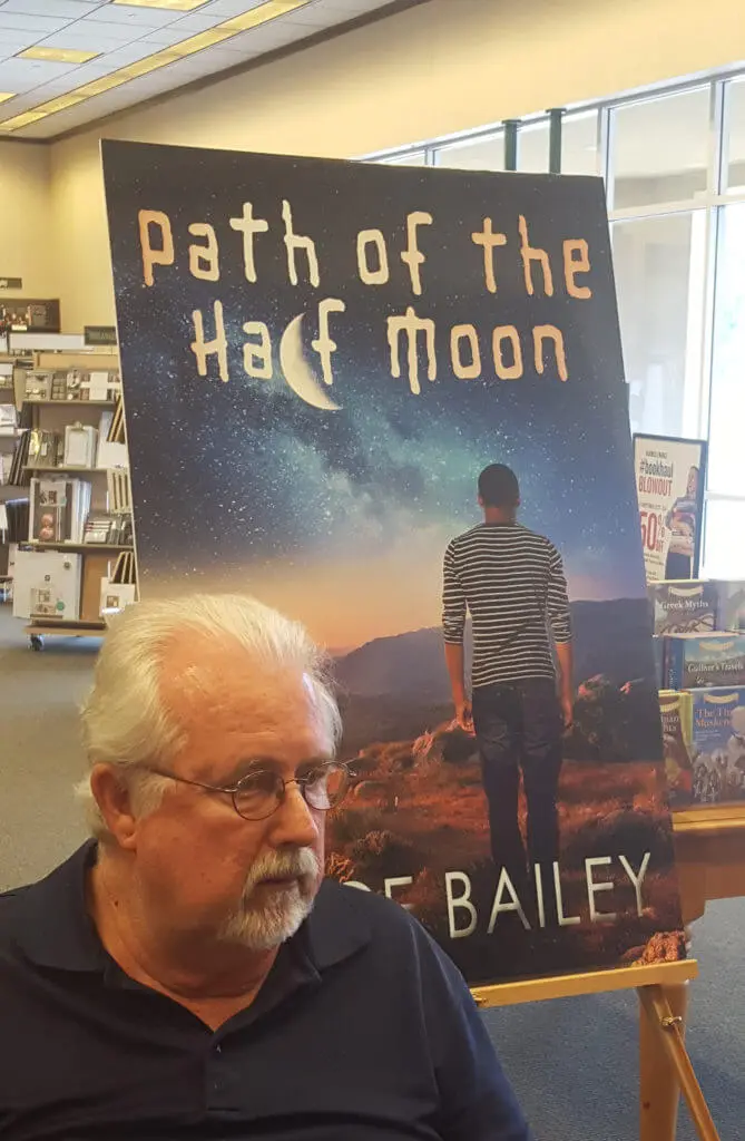 A man sitting in front of a book cover.